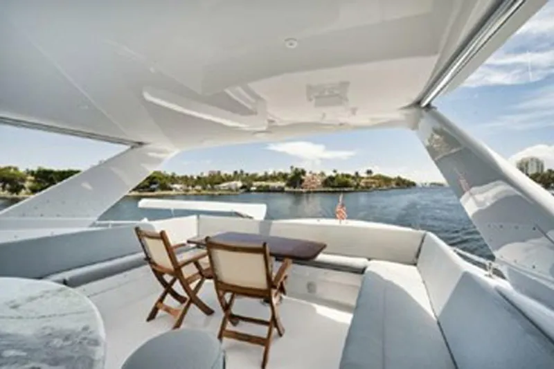 Slide: The Image of Luxurious 1998 Hatteras 74 Cockpit Motor Yacht with elegant outdoor seating and scenic water view. - 48