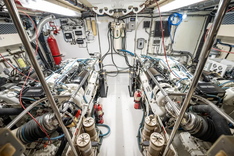 Slide: The Image of Engine room of 1998 Hatteras 74 Cockpit Motor Yacht, featuring dual engines and control systems. - 53