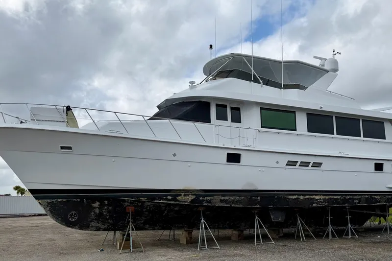 Slide: The Image of 1998 Hatteras 74 Cockpit Motor Yacht on dry dock under cloudy sky. - 61