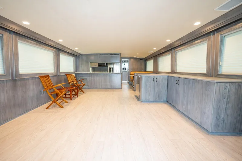 Slide: The Image of Interior of 1998 Hatteras 74 Cockpit Motor Yacht with wooden chairs and cabinetry. - 8