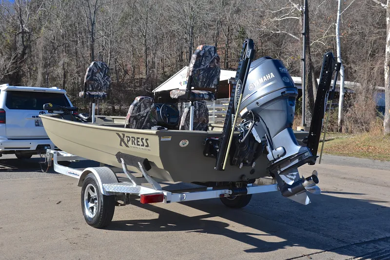 Slide: The Image of 2013 Express Xp170 boat on trailer with Yamaha motor, parked outdoors. - 12