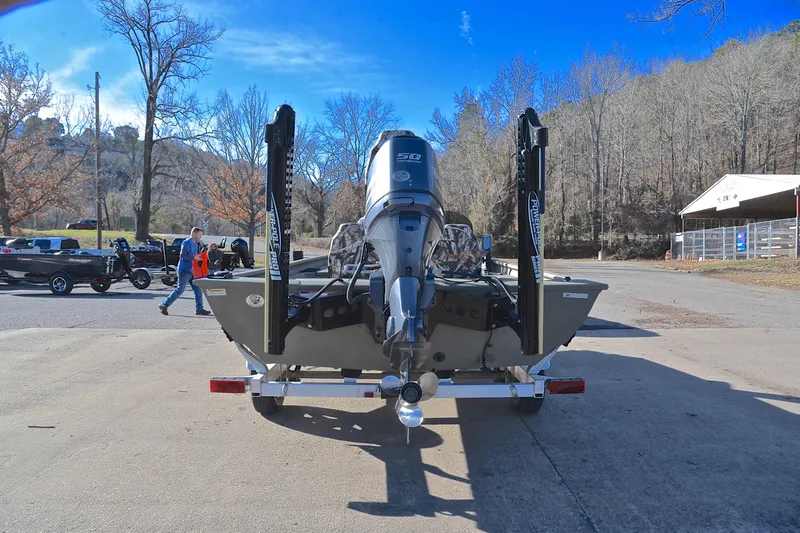 Slide: The Image of 2013 Express Xp170 boat on trailer, parked outdoors with trees in background. - 13
