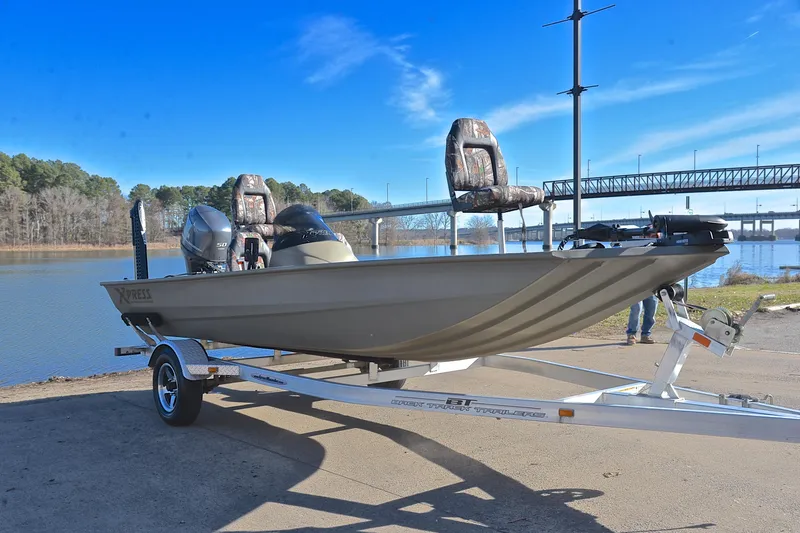 Slide: The Image of 2013 Express Xp170 boat on trailer by a lake, clear blue sky background. - 16