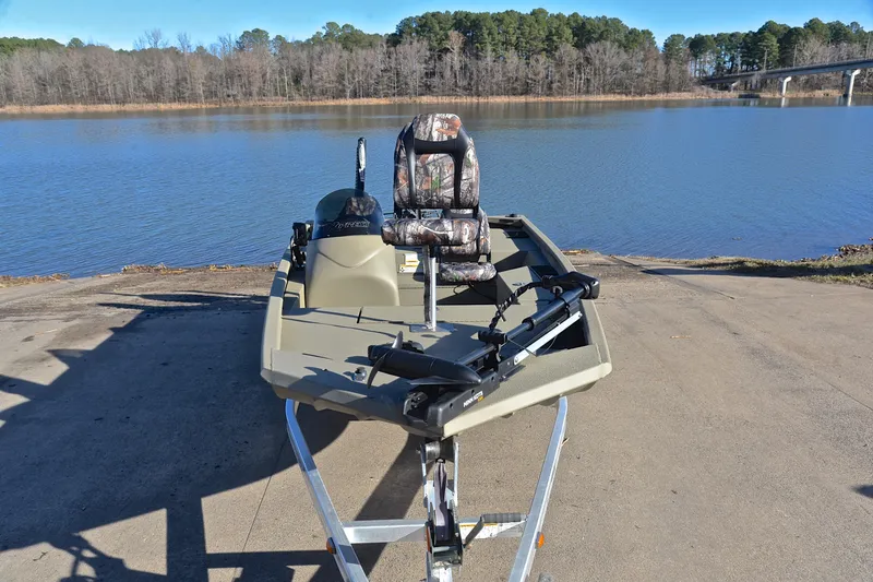 Slide: The Image of 2013 Express Xp170 boat on trailer by a serene lake with wooded background. - 17