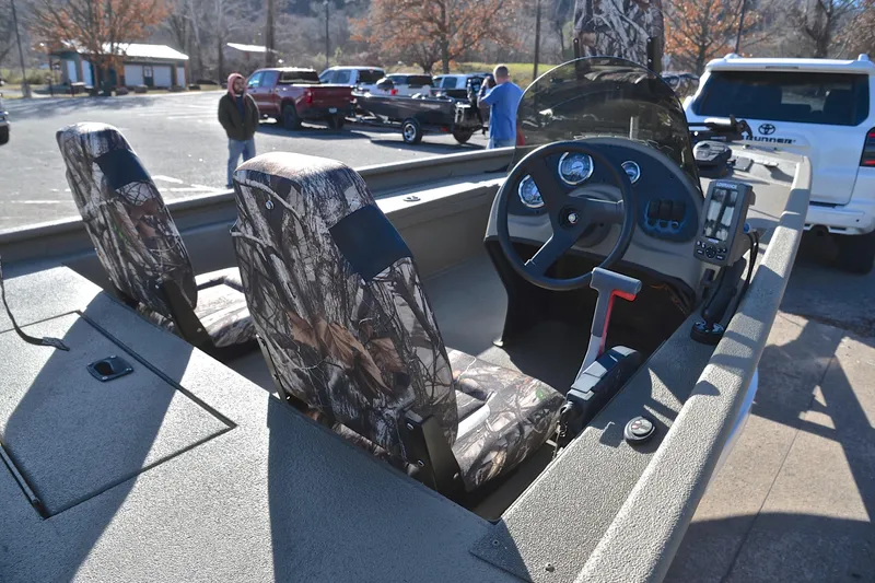 Slide: The Image of 2013 Express Xp170 boat interior with camouflage seats and dashboard in a parking lot. - 19