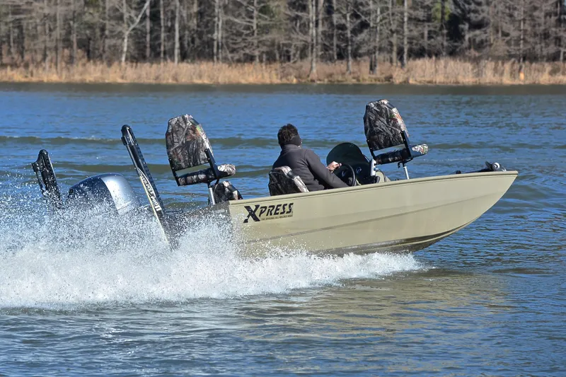 Slide: The Image of 2013 Express Xp170 boat speeding on a lake with camo seats and outboard motor. - 5