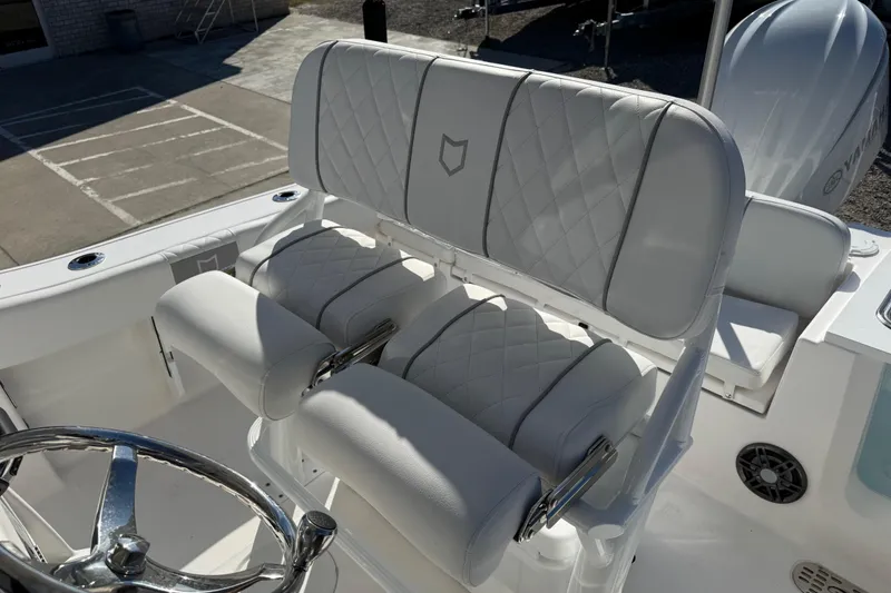 Slide: The Image of 2025 Sea Fox 228 Commander boat interior with white cushioned seating and steering wheel. - 23