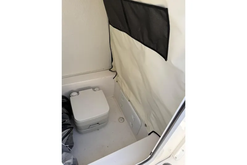 Slide: The Image of 2025 Sea Fox 228 Commander boat interior with portable toilet and storage area. - 32