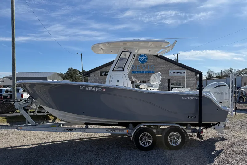 Slide: The Image of 2025 Sea Fox 228 Commander boat on trailer at dealership under blue sky. - 5