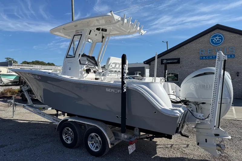Slide: The Image of 2025 Sea Fox 228 Commander boat on trailer at dealership, clear sky background. - 6