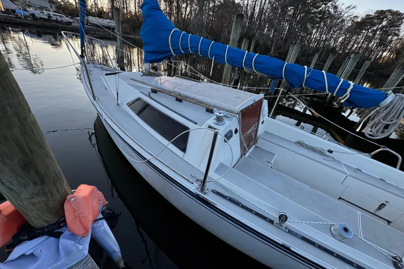 Slide: The Image of 1984 O'Day 222 sailboat docked, featuring blue sail cover and white deck. - 15