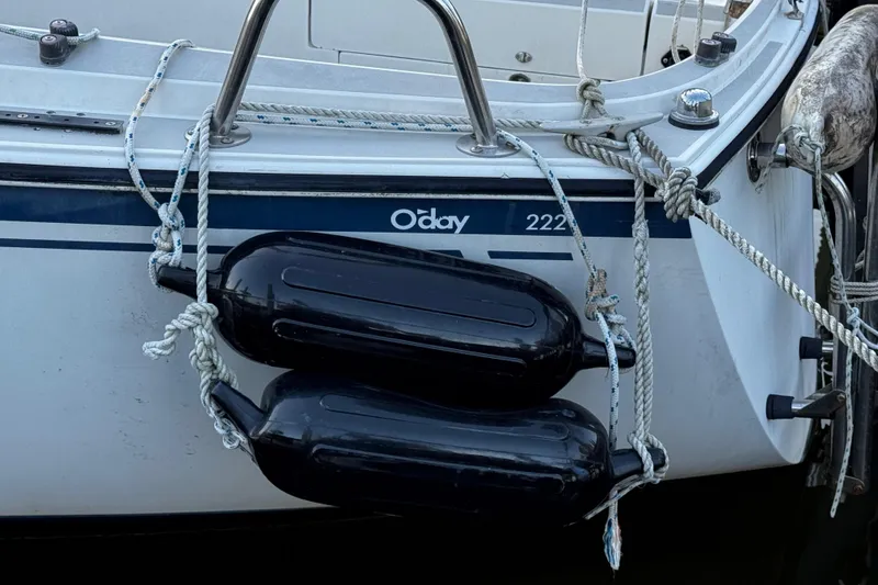 Slide: The Image of 1984 O'Day 222 sailboat with black fenders and ropes on the side. - 29