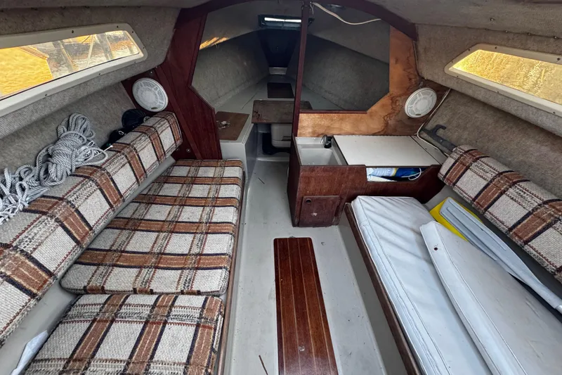 Slide: The Image of Interior of a 1984 O'Day 222 sailboat with plaid seating and compact cabin layout. - 51