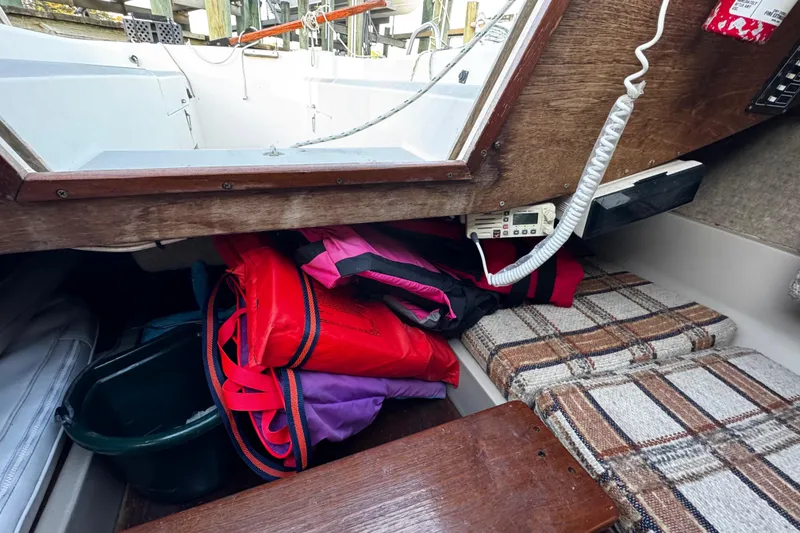 Slide: The Image of Interior of 1984 O'Day 222 sailboat with life jackets and plaid cushions. - 56