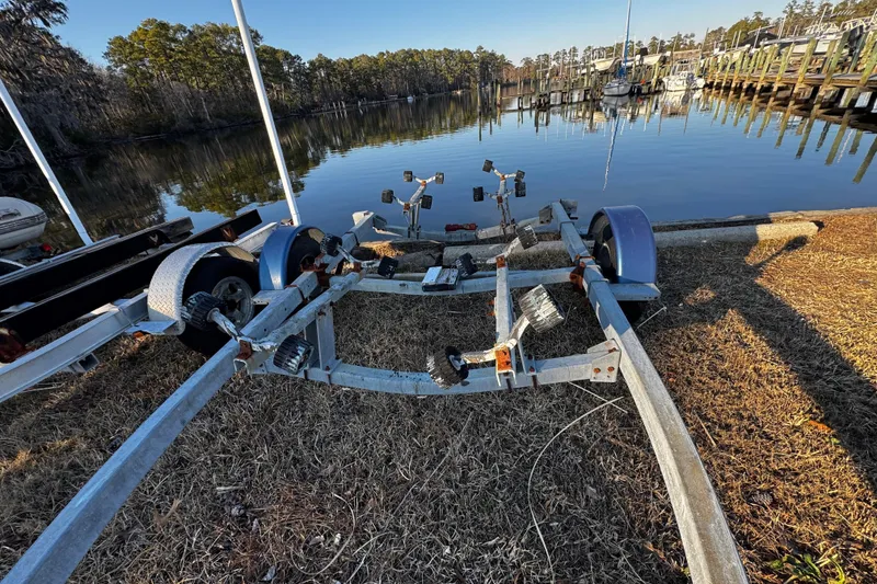 Slide: The Image of Boat trailer near a calm lake, surrounded by trees and docks, O'Day 222, 1984. - 61