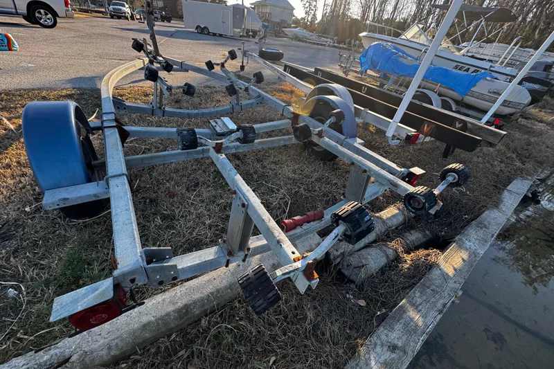 Slide: The Image of Boat trailer on grass near water, surrounded by parked vehicles and boats. - 62