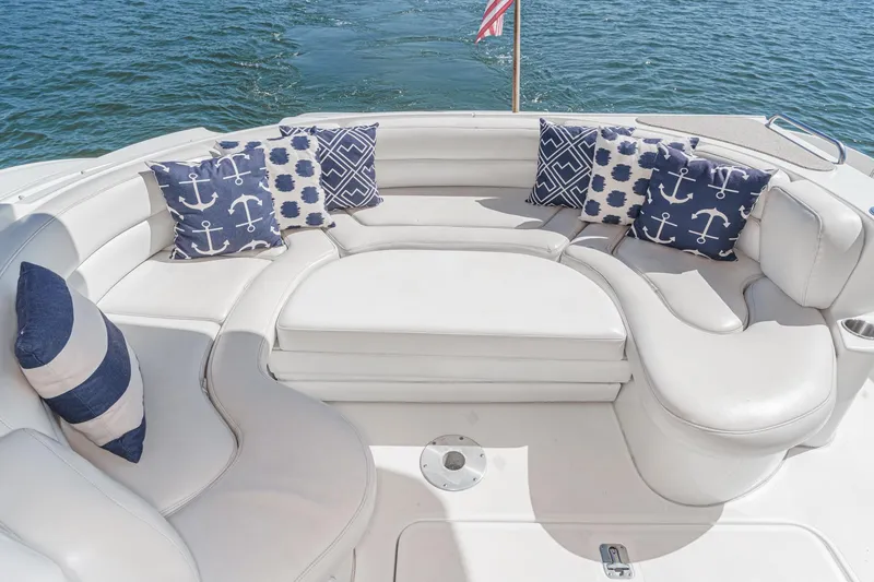 Slide: The Image of 2004 Cruisers Yachts 540 Express with white seating and nautical-themed pillows on deck. - 16