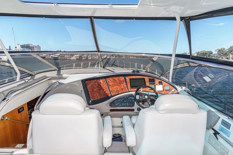Slide: The Image of 2004 Cruisers Yachts 540 Express helm with luxurious white seating and panoramic view. - 22