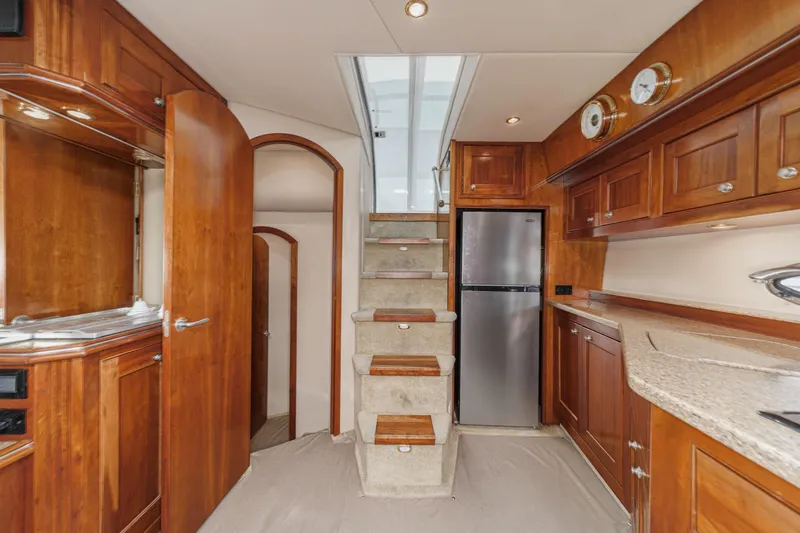 Slide: The Image of Interior of 2004 Cruisers Yachts 540 Express with wooden cabinetry and modern kitchen amenities. - 26