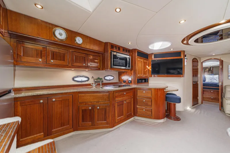 Slide: The Image of Luxurious 2004 Cruisers Yachts 540 Express interior with elegant wood cabinetry and modern amenities. - 28