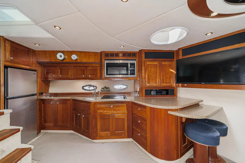 Slide: The Image of Luxurious 2004 Cruisers Yachts 540 Express interior with modern kitchen and elegant wood cabinetry. - 29