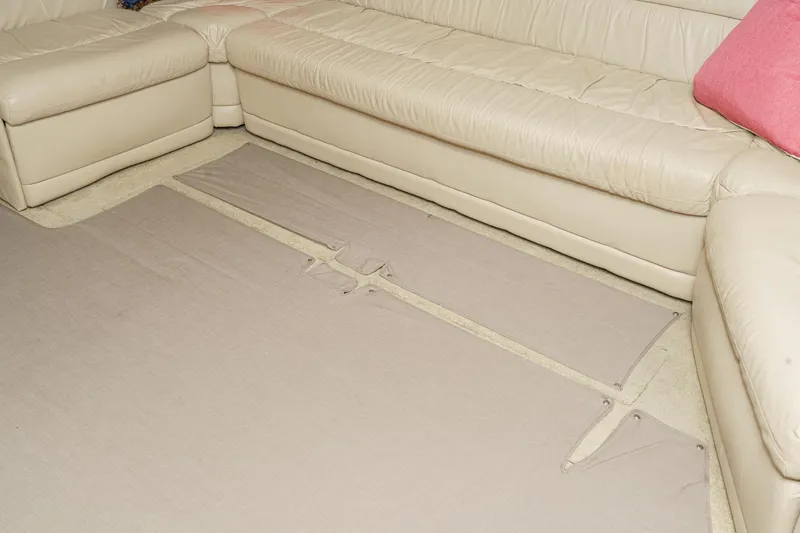 Slide: The Image of Beige leather sectional sofa with pink cushion and beige carpet pieces on floor. - 42