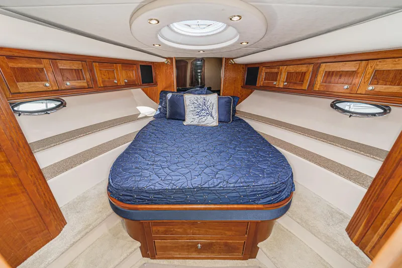 Slide: The Image of Luxurious 2004 Cruisers Yachts 540 Express cabin with elegant wood cabinetry and plush bedding. - 51