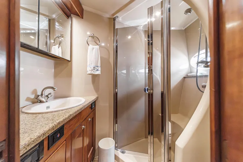 Slide: The Image of Luxurious bathroom in 2004 Cruisers Yachts 540 Express with granite countertop and glass shower. - 56