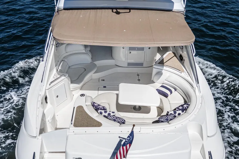 Slide: The Image of 2004 Cruisers Yachts 540 Express, spacious deck with seating, cruising on open water. - 10