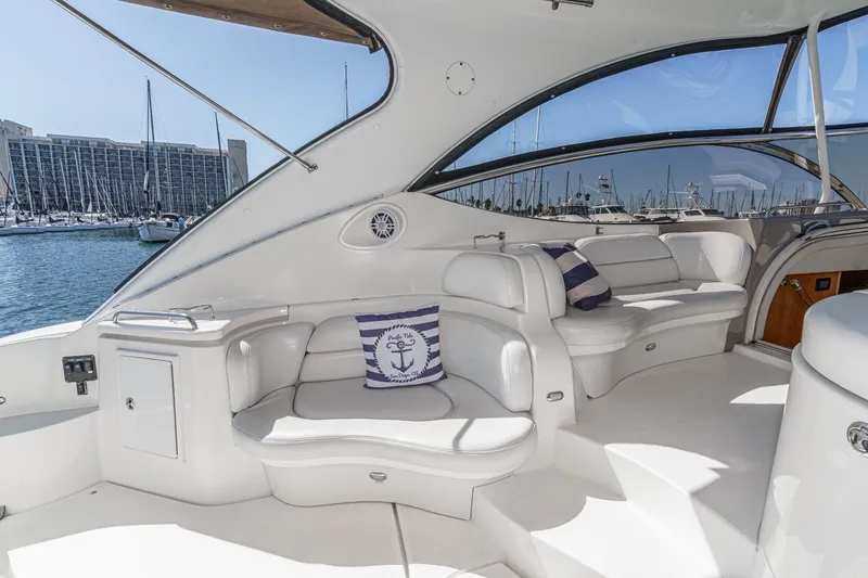 Slide: The Image of Luxurious 2004 Cruisers Yachts 540 Express interior with plush seating and marina view. - 17