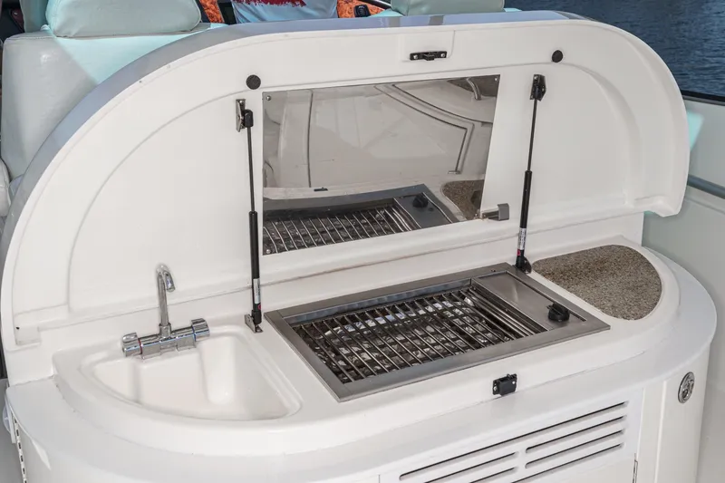 Slide: The Image of 2004 Cruisers Yachts 540 Express boat interior with sink and grill setup. - 19