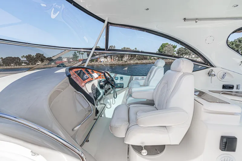 Slide: The Image of 2004 Cruisers Yachts 540 Express helm with luxurious white seating and panoramic windows. - 21