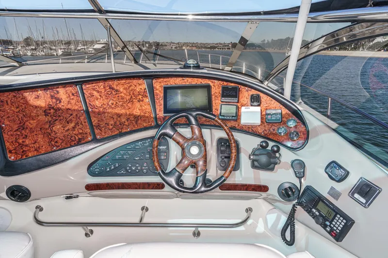 Slide: The Image of Cockpit of 2004 Cruisers Yachts 540 Express with wood paneling and navigation instruments. - 23