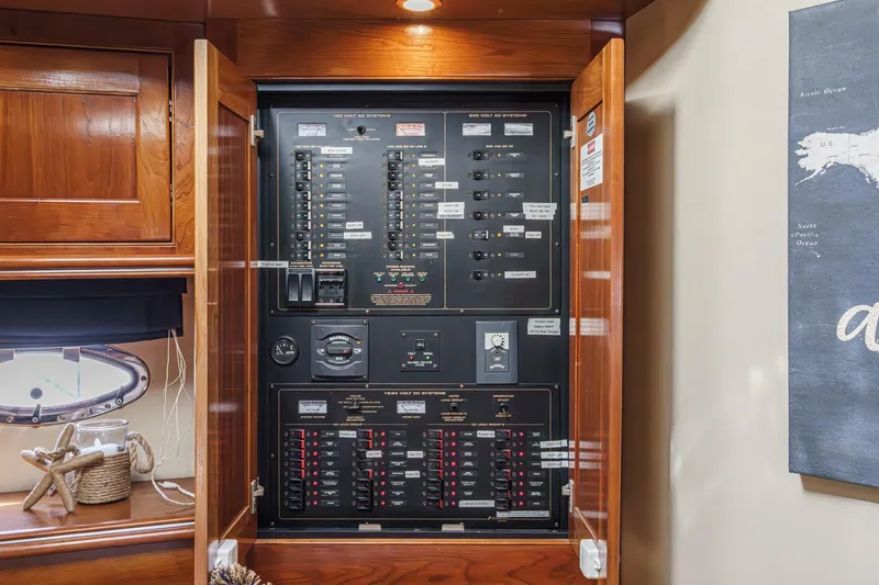 Slide: The Image of Electrical panel inside 2004 Cruisers Yachts 540 Express, showcasing circuit breakers and controls. - 49