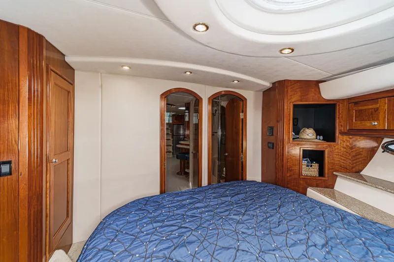 Slide: The Image of Luxurious 2004 Cruisers Yachts 540 Express cabin interior with wood accents and blue bedding. - 52