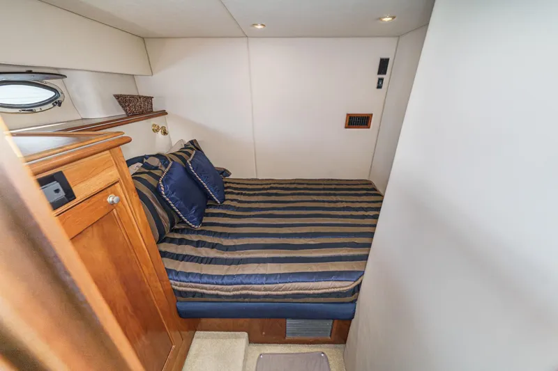 Slide: The Image of Luxurious cabin interior of 2004 Cruisers Yachts 540 Express with striped bedding. - 55