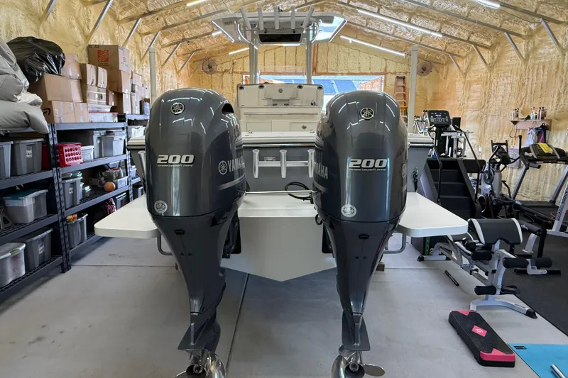 Slide: The Image of 2022 Parker 2501 Center Console boat with twin Yamaha 200 engines in a garage. - 11