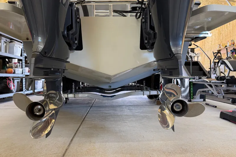 Slide: The Image of 2022 Parker 2501 Center Console boat with dual outboard motors in a garage. - 17