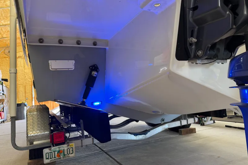 Slide: The Image of 2022 Parker 2501 Center Console boat on trailer with blue LED lights in a garage. - 18