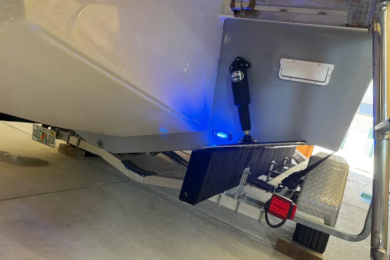 Slide: The Image of 2022 Parker 2501 Center Console boat on trailer, illuminated by blue LED lights. - 19
