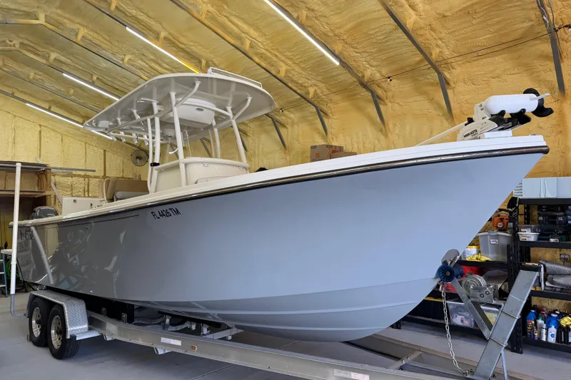 Slide: The Image of 2022 Parker 2501 Center Console boat on trailer in a garage. - 2