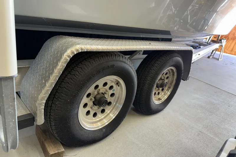 Slide: The Image of Trailer wheels of a 2022 Parker 2501 Center Console boat in a garage. - 29