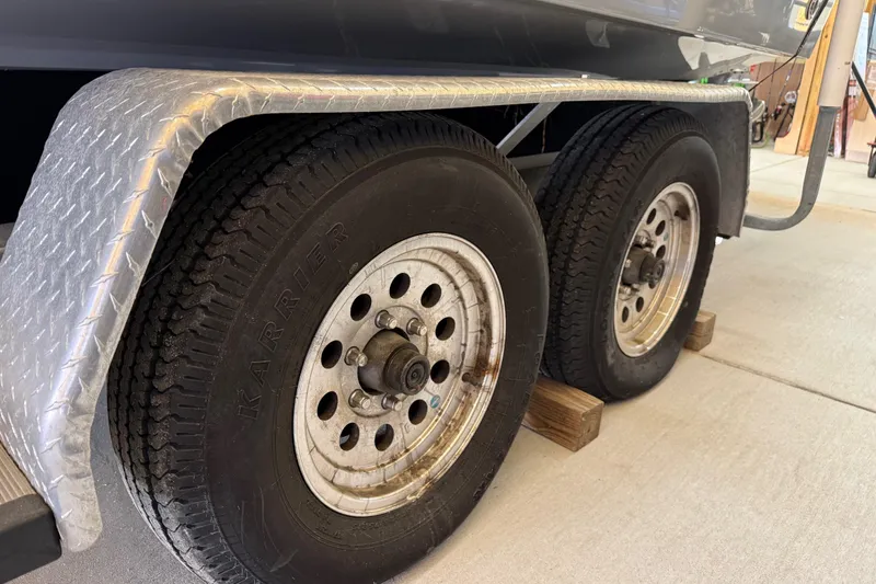Slide: The Image of Trailer wheels of a 2022 Parker 2501 Center Console boat on wooden blocks. - 30