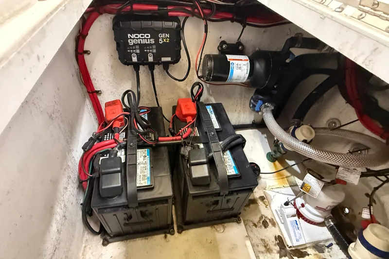 Slide: The Image of 2022 Parker 2501 Center Console boat battery compartment with NOCO Genius charger and wiring. - 43