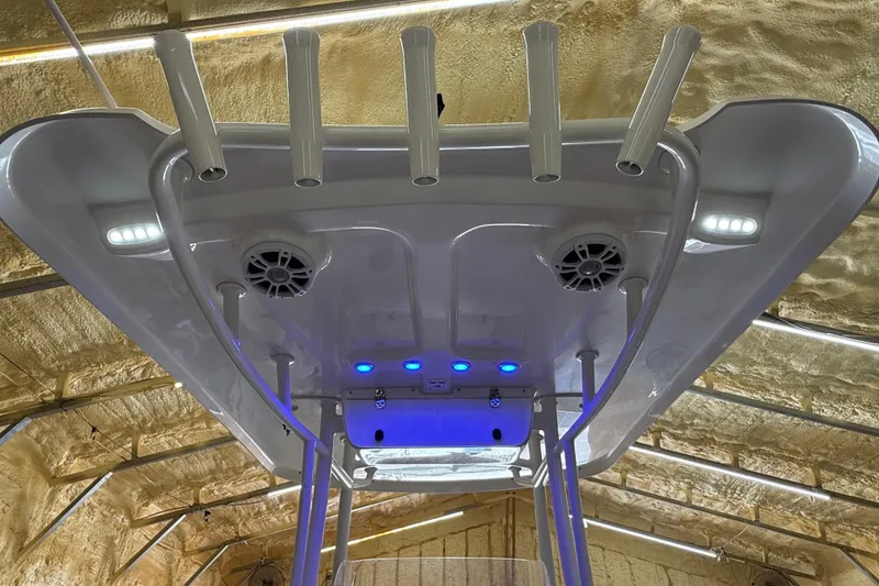 Slide: The Image of 2022 Parker 2501 Center Console boat with rod holders and LED lights in a workshop. - 52