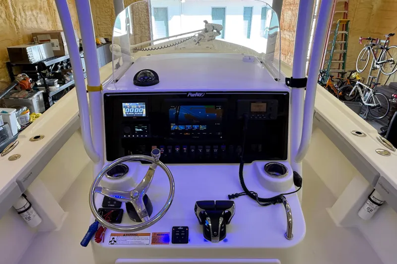 Slide: The Image of 2022 Parker 2501 Center Console boat dashboard with steering wheel and navigation controls. - 58