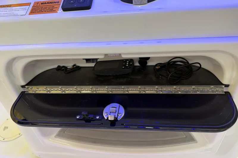 Slide: The Image of Storage compartment on a 2022 Parker 2501 Center Console boat with electronic accessories. - 60