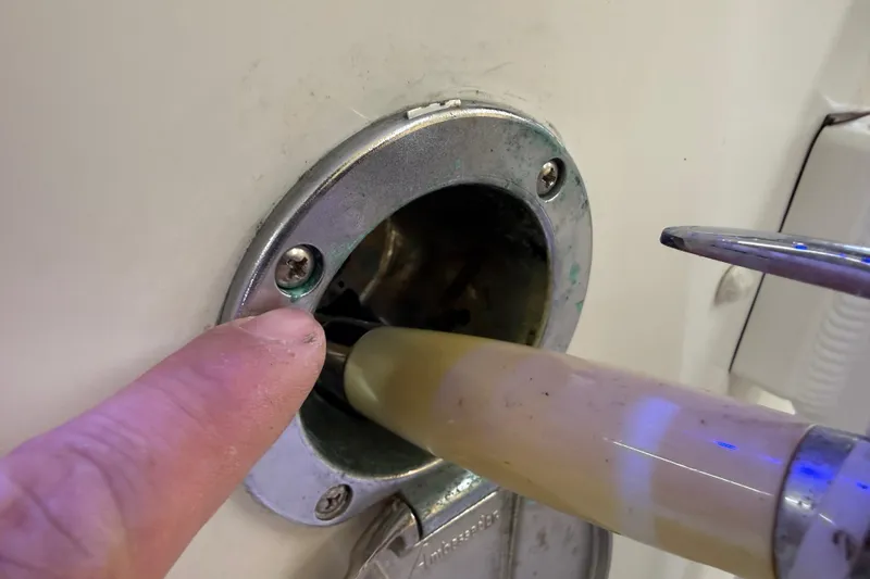 Slide: The Image of Close-up of a Parker 2501 Center Console 2022 fuel port with a finger pointing. - 67