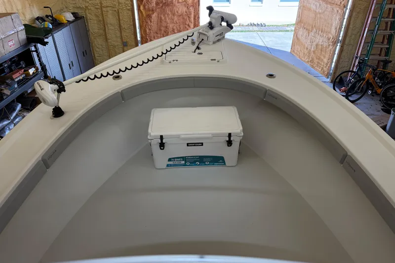Slide: The Image of 2022 Parker 2501 Center Console boat interior with cooler and equipment in a garage. - 76