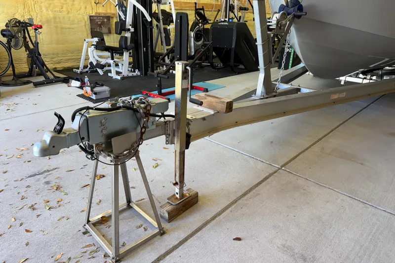 Slide: The Image of 2022 Parker 2501 Center Console boat trailer in a garage with gym equipment. - 9